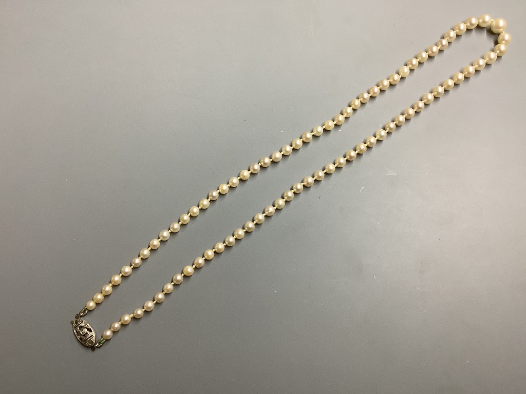 A single strand graduated cultured pearl necklace with rose cut diamond set 9 carat white gold class, 48 cm an amber necklace and three other necklaces.